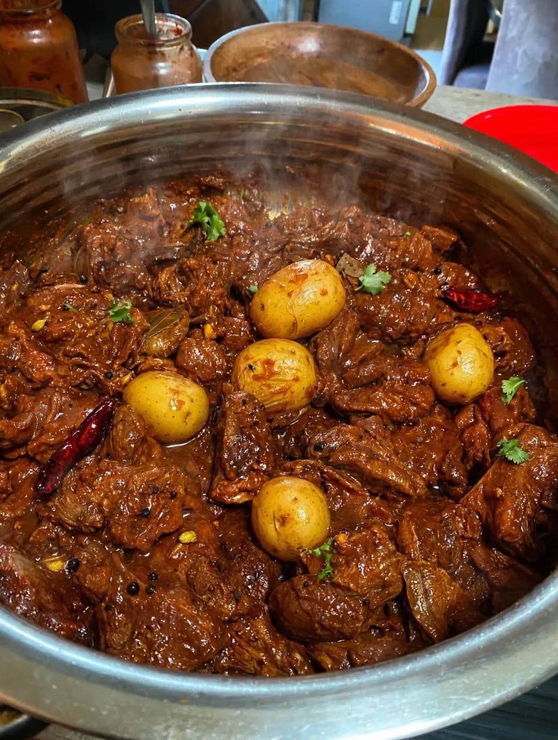 A pot of slow-cooked beef curry with potatoes and whole spices