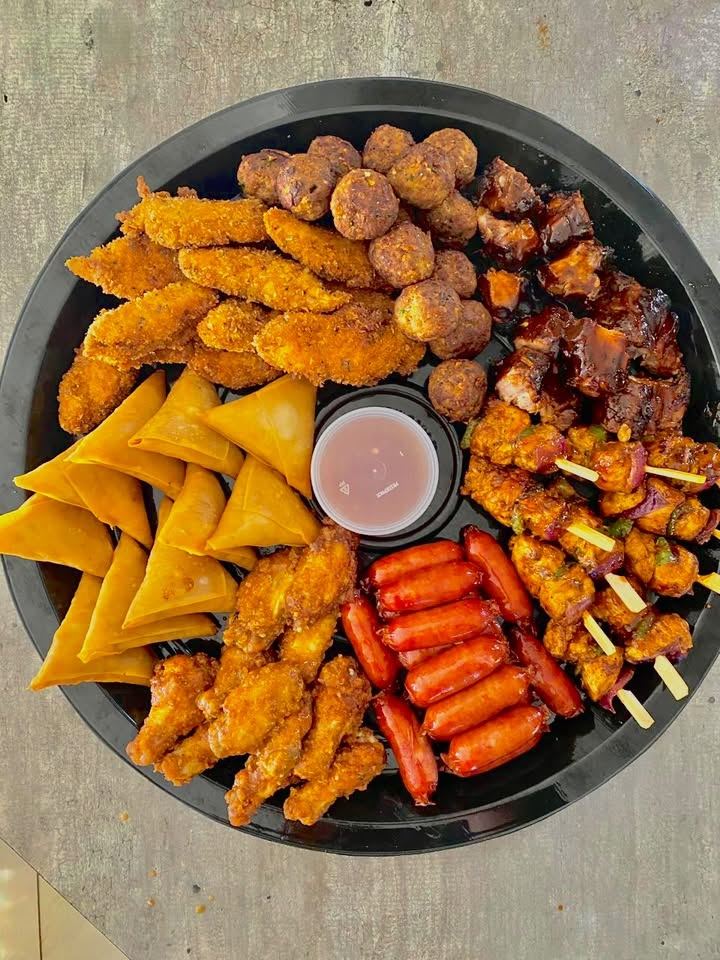 Meaty platter with chicken strips, meatballs, sticky ribs, chicken kebabs, cocktail sausages, wings and samoosas around a dipping sauce